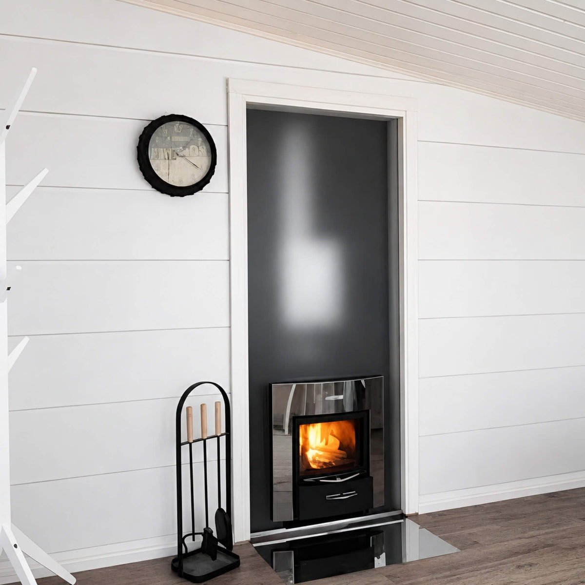 Harvia Duo stove installed through a wall in a room with fireplace tools
