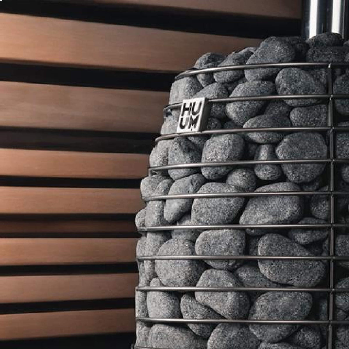 Close view of stacked stones and the Huum logo on the Hive Flow Mini stove