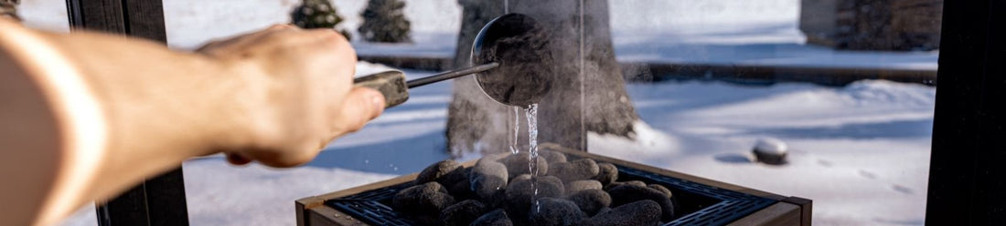 Wooden sauna in snow illustrating the order of sauna and cold plunge in contrast therapy
