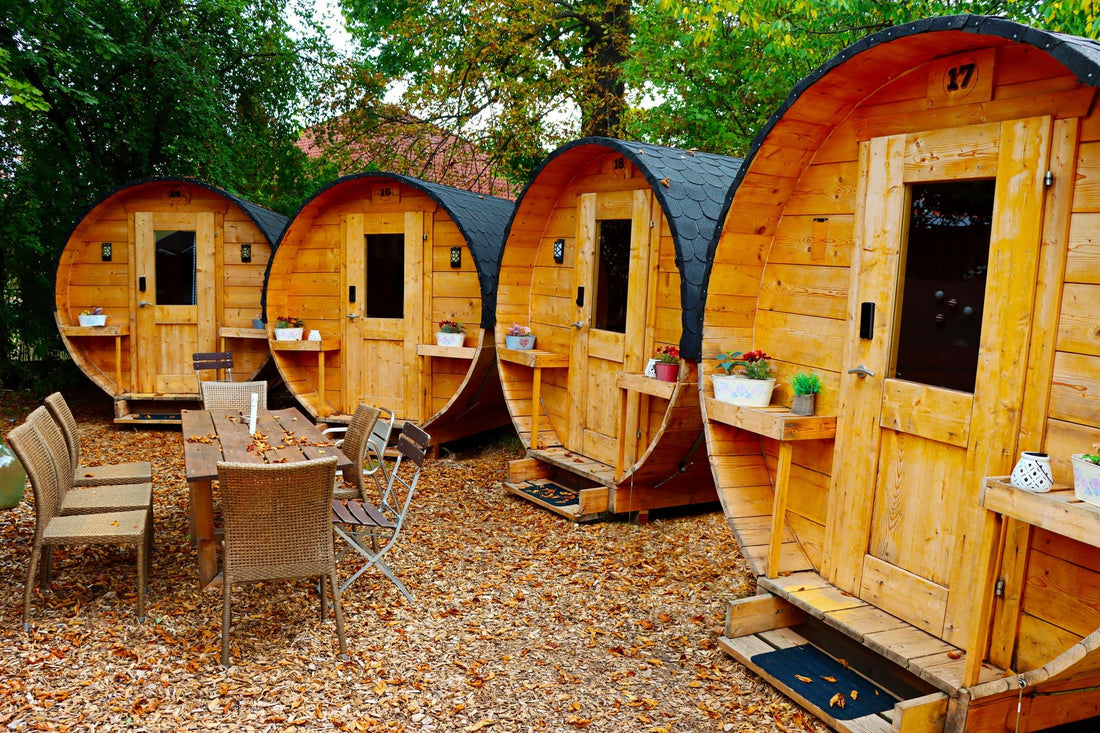 Row of wooden barrel saunas in an outdoor courtyard