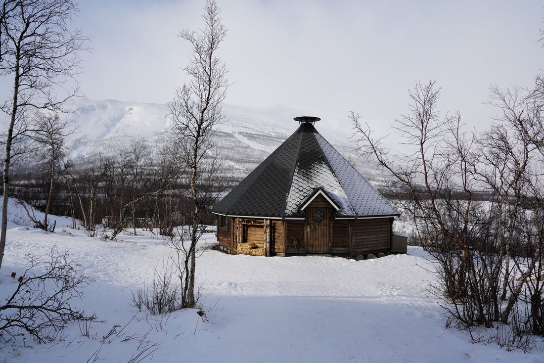 Wooden outdoor sauna cabin in a snowy winter mountain landscape