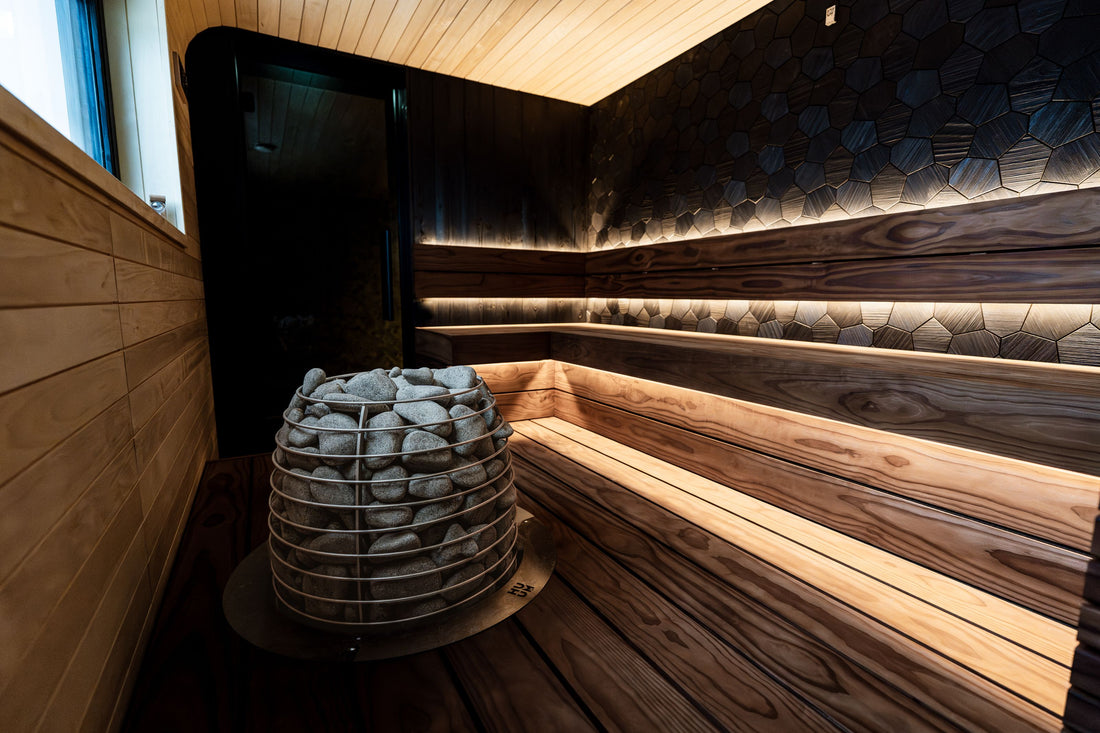 Modern traditional sauna interior with heated rocks and cedar benches