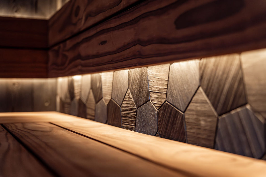 Clean infrared sauna interior with textured wood-panel walls, warm LED lighting and a cedar bench