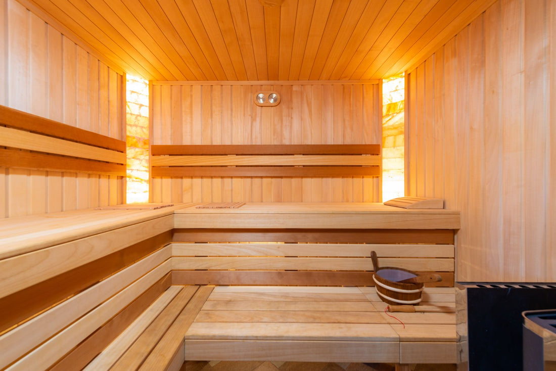 Bright wooden home infrared sauna interior with cedar benches and backlit walls