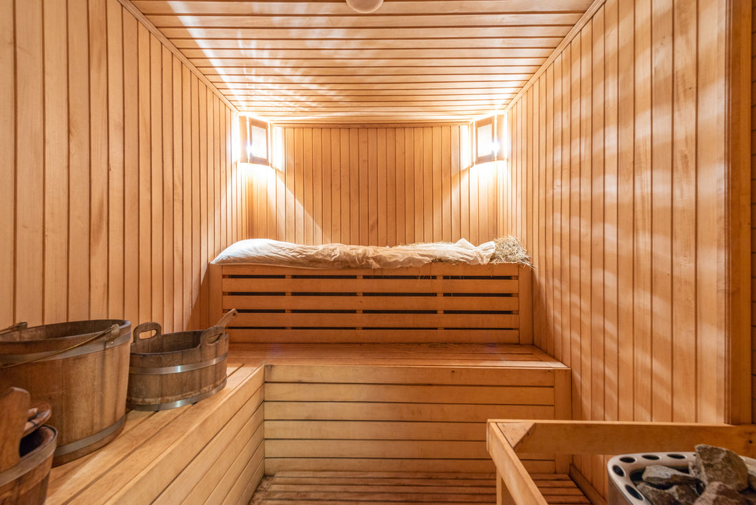 Warm wooden home sauna interior with benches and buckets
