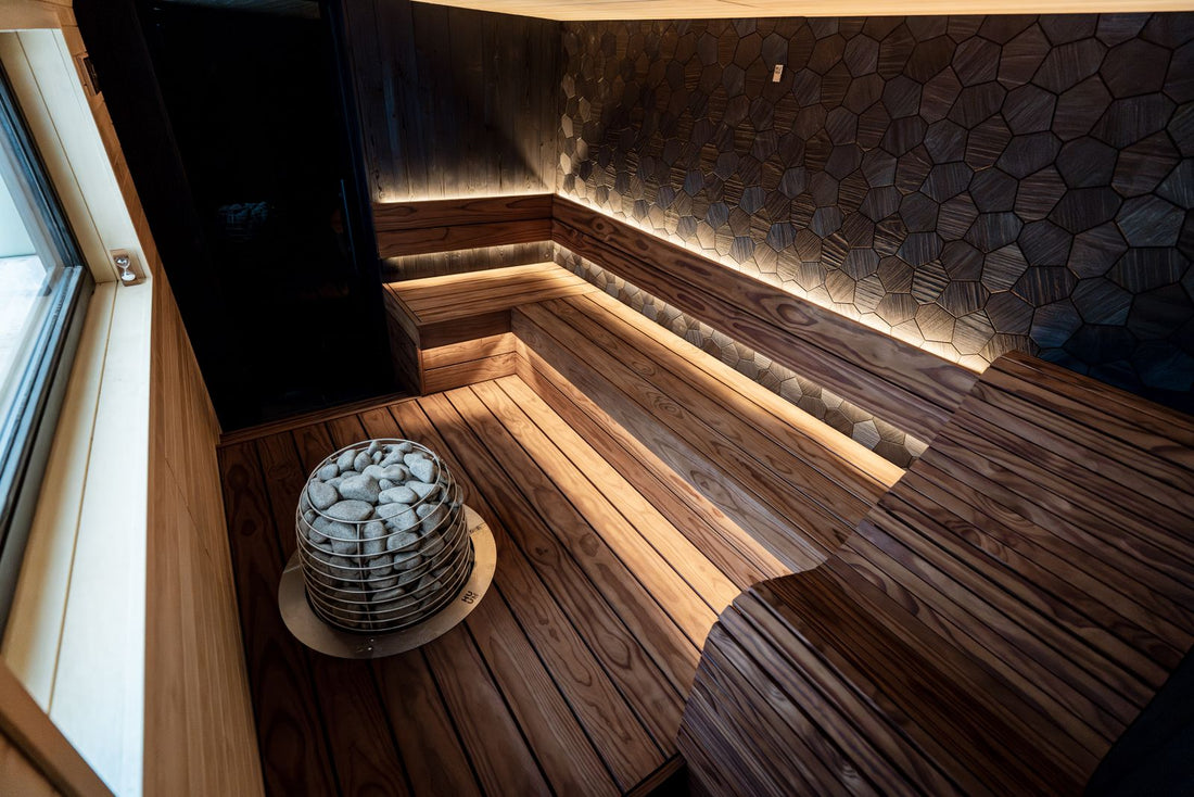 Modern wood-paneled home sauna interior with tiered benches and LED accent lighting