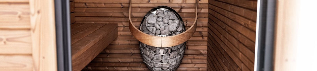 Hybrid sauna interior combining infrared panels and a traditional stone heater in a wood cabin