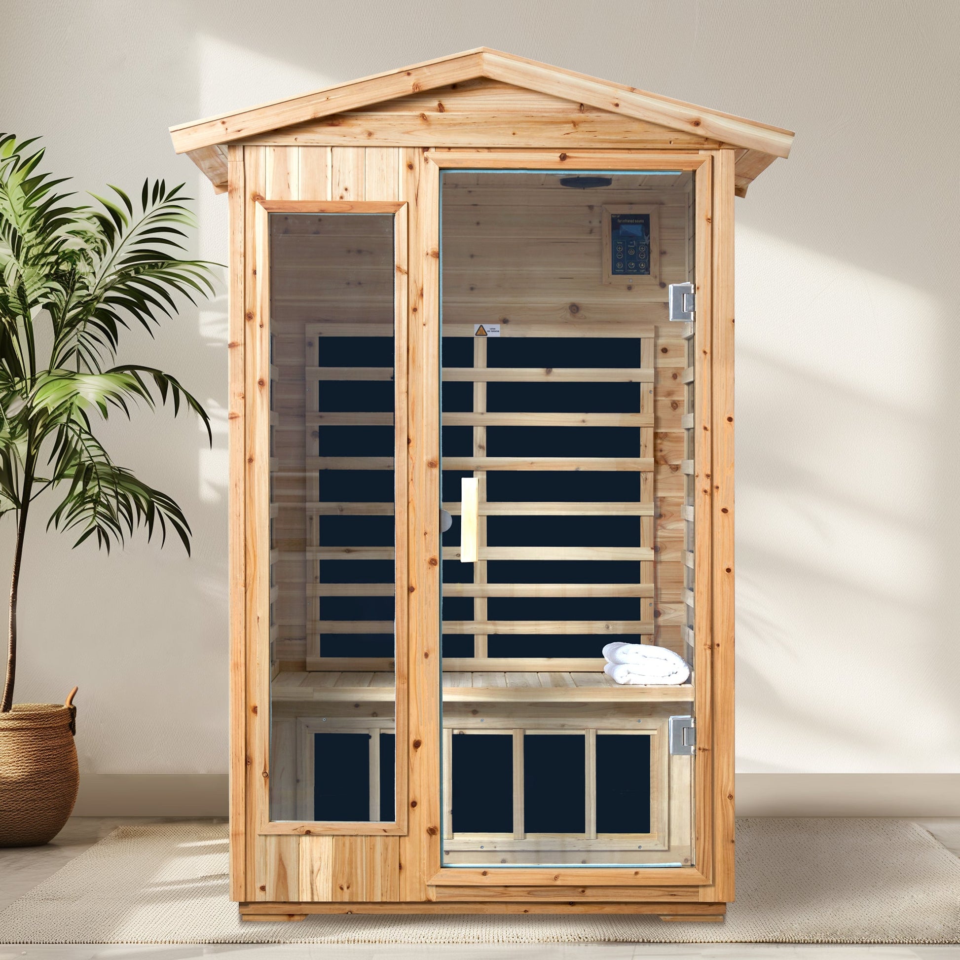Two person old fir sauna room with folded towels on the bench beside a potted palm