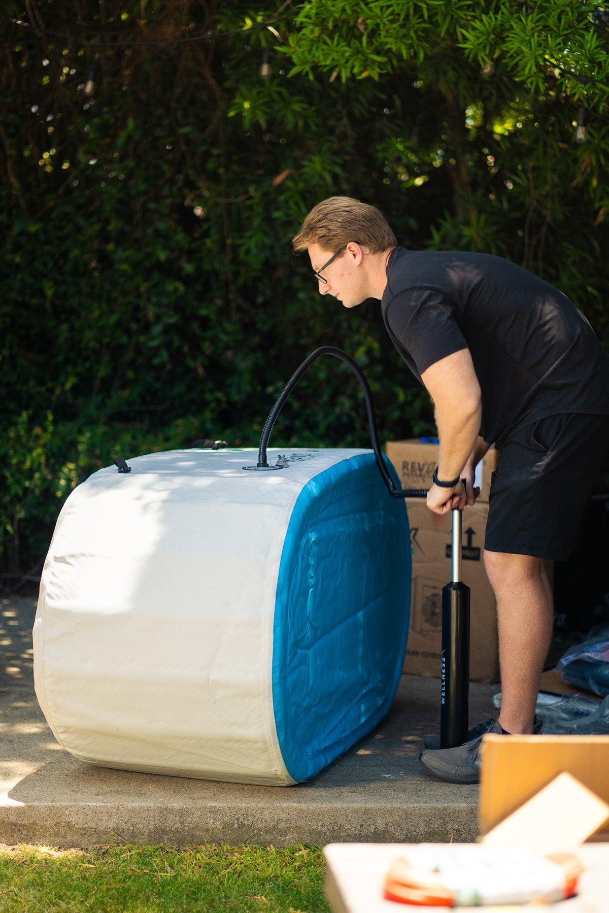 Person inflating the RevX Inflatable Classic with the included manual air pump