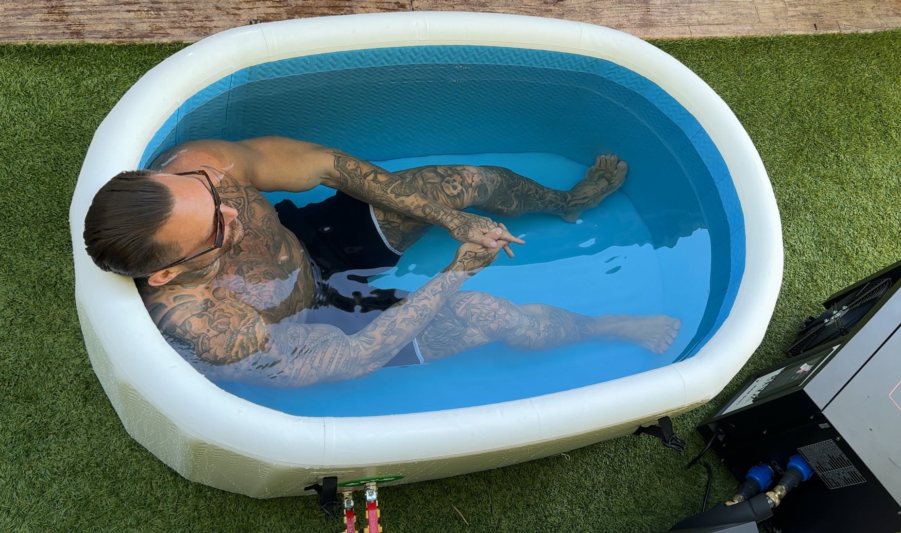Person submerged in a RevX Inflatable Classic on grass, viewed from above