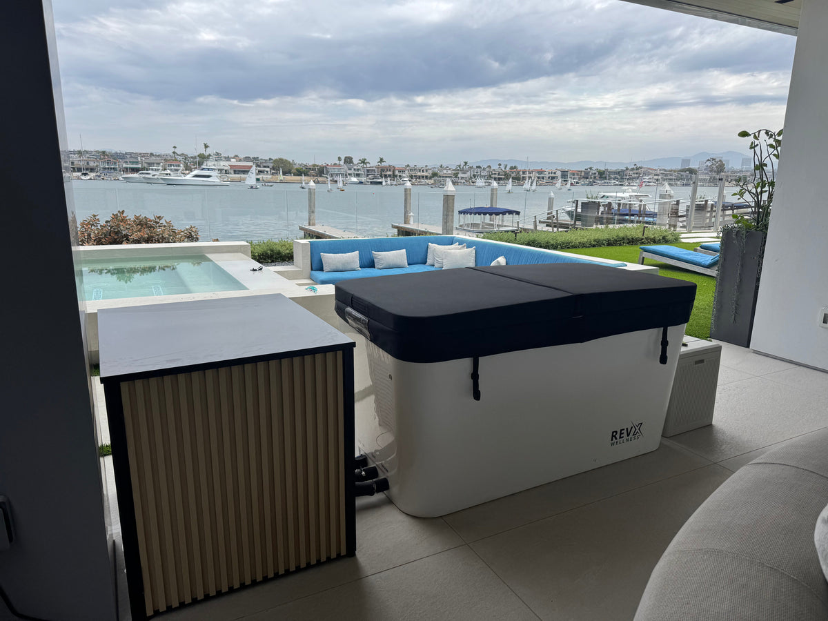 RevX X Tub cold plunge with wood panel chiller cabinet on an outdoor waterfront patio