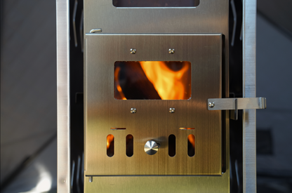 Firebox of the North Shore Sauna portable sauna tent wood stove with a wood fire burning