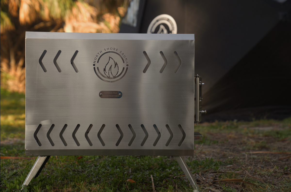 Portable stainless steel sauna tent wood stove, angled view, North Shore Sauna