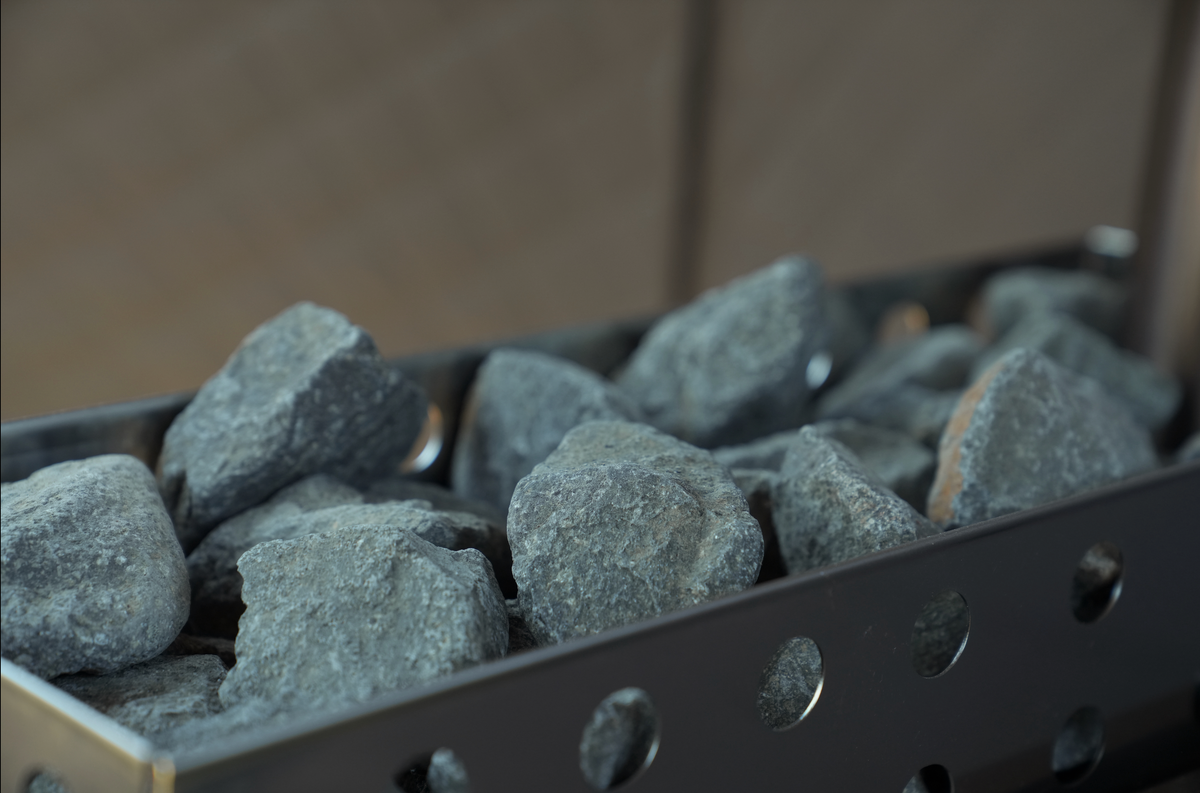 Dark grey Olivine Gabbro thermal sauna stones in a sauna heater basket, North Shore Sauna