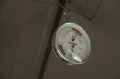 Close view of the North Shore Sauna sauna thermometer and hygrometer dial and scale