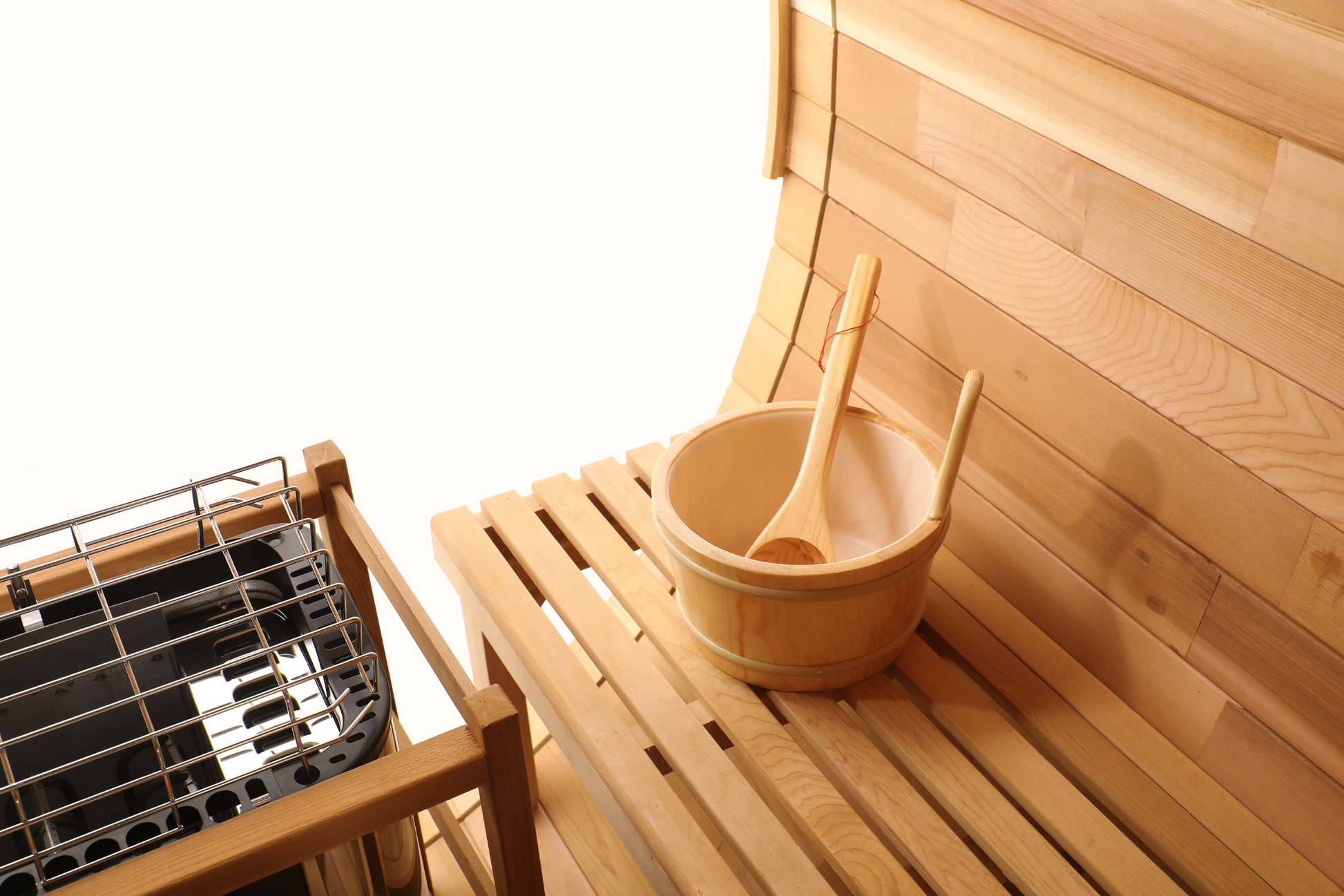 Cedar bucket and ladle on the bench beside the heater inside the Blisspod Prague sauna