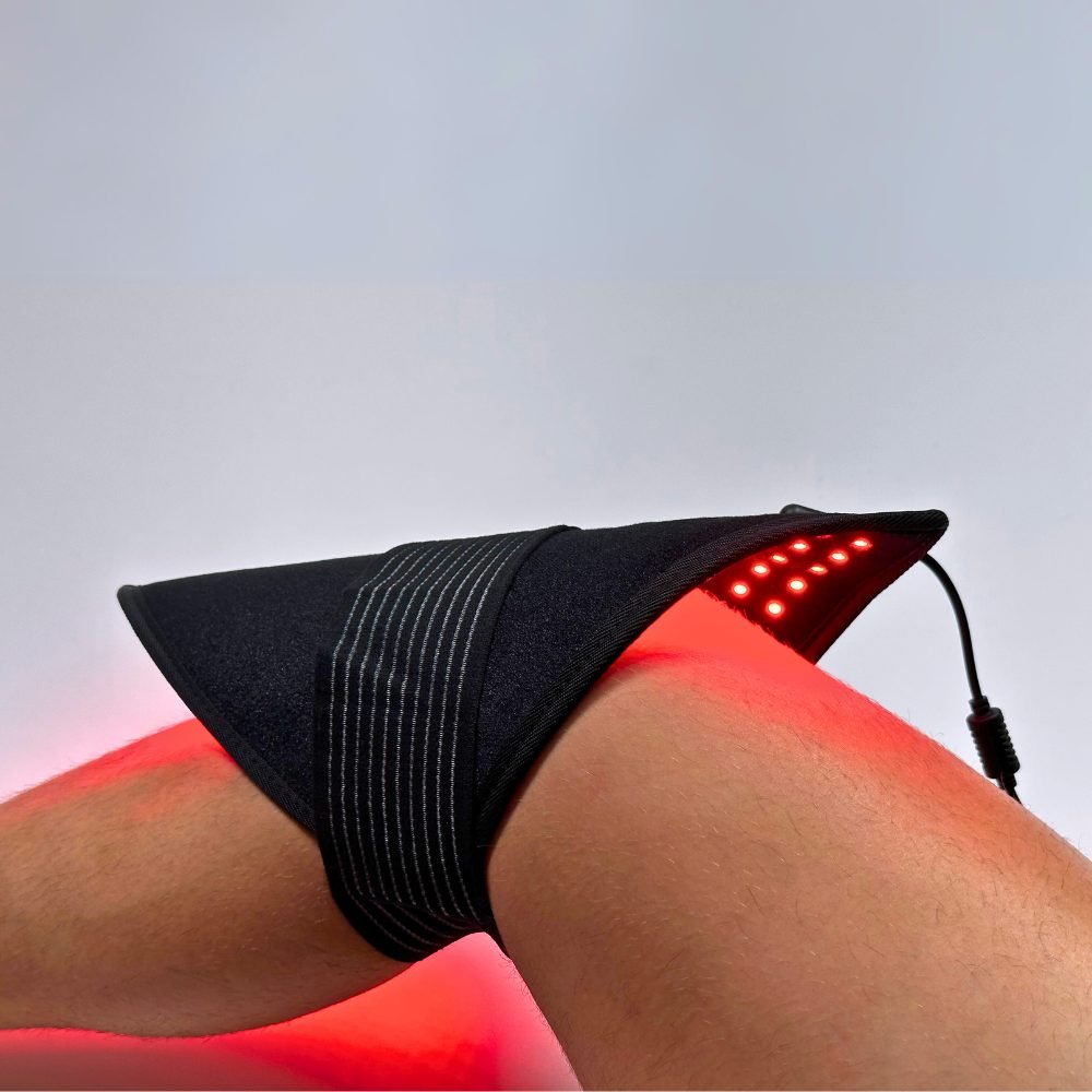 Lumara red light therapy pad strapped around a knee with the LEDs lit