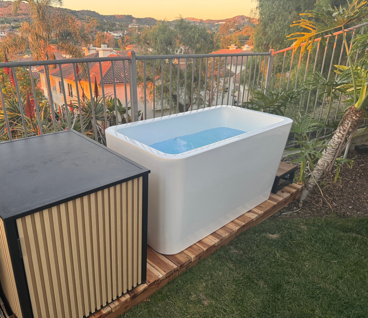 Filled RevX X Tub cold plunge on a hillside deck with the chiller cabinet alongside