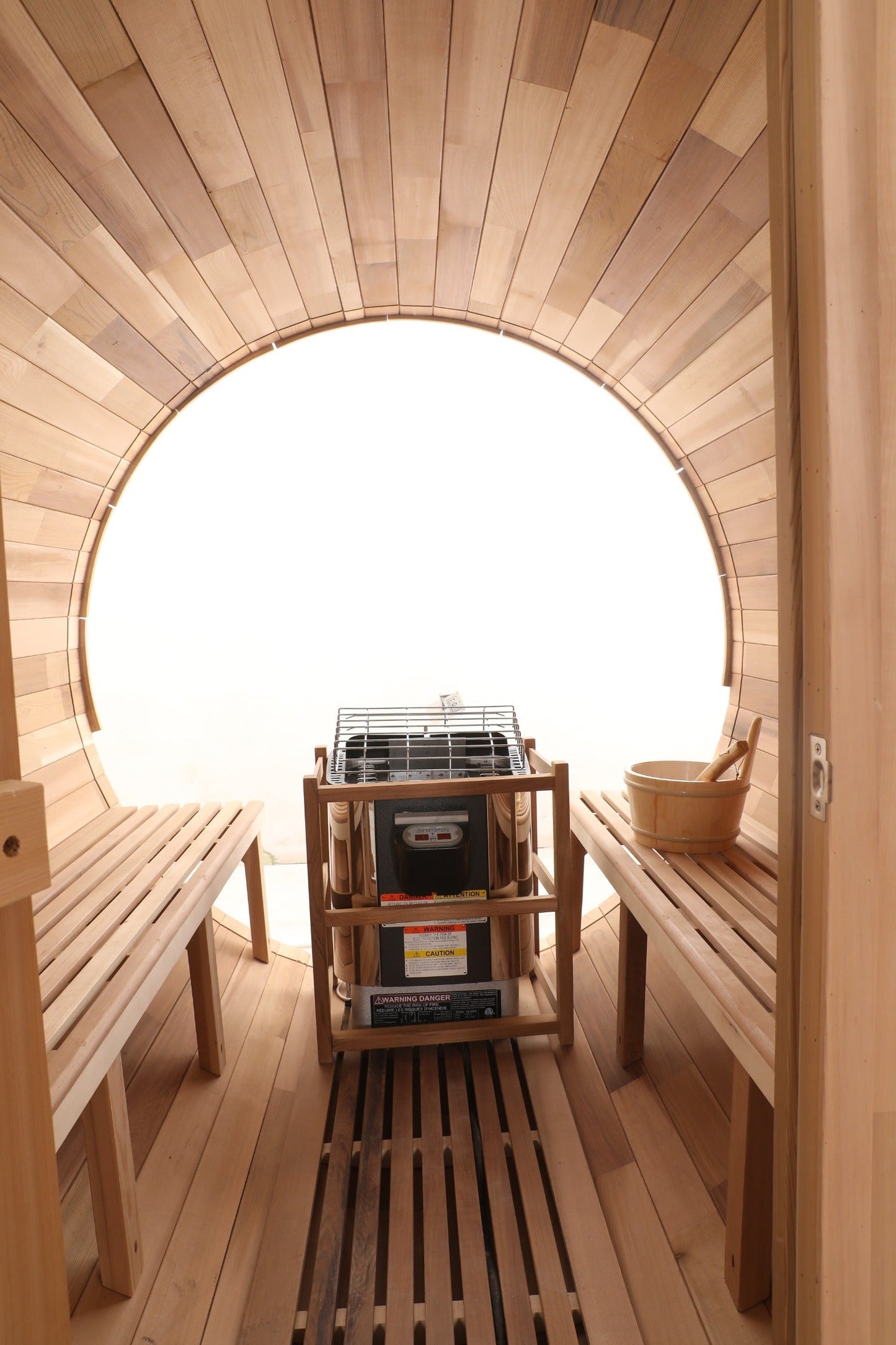 Interior of the Blisspod Prague barrel sauna with cedar benches, heater and full glass back