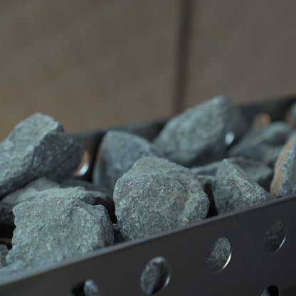 Thermal sauna stones, olivine gabbro, in a sauna heater basket